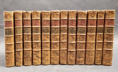 several old books are lined up in a row on a table