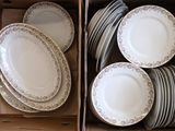 beaucoup d'assiettes dans une boîte posée par terre