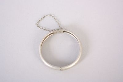 bague en argent à laquelle est suspendue une chaîne sur le côté