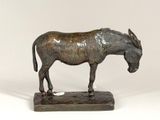 a bronze statue of a donkey on a wooden base