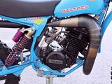 a blue dirt bike parked on the side of the road