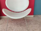 a white chair sitting in front of a red wall