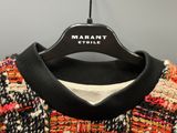 the sweater is hanging on a hanger on the wall