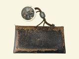 an old purse with a coin on it and a necklace