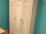 a large white locker in the corner of a room next to a table