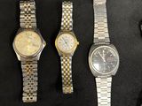three watches and a watch on a table with a watch in the middle