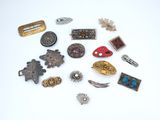 several different types of brooches and pins on a white surface