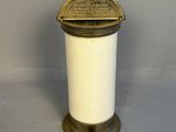 an antique brass and white candle holder on a grey background