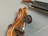 a violin that is being worked on with a pair of pliers