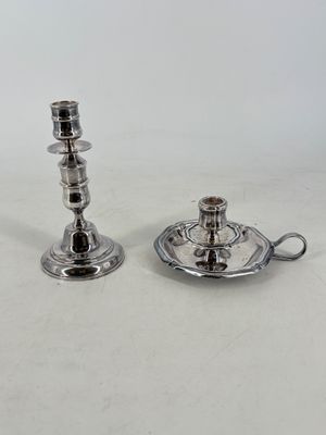pair of silver plated candlesticks on a saucer and saucer