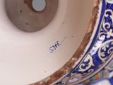 a close up of a blue and white vase on a table