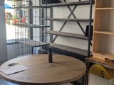 a wooden table with a metal base in the middle of a room
