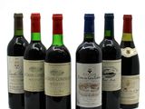 several bottles of wine are lined up on a white surface