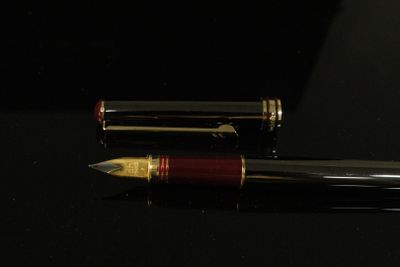 Daniel HECHTER. Stylo plume noir et rouge à garniture dorée.