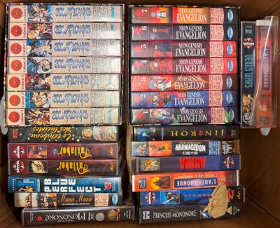 un grand nombre de dvd dans une boîte posée sur le sol