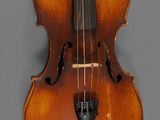 a close up of a violin on a gray surface