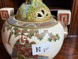 a large vase with a bird on it on a table