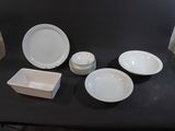 a black table with white plates and bowls on it
