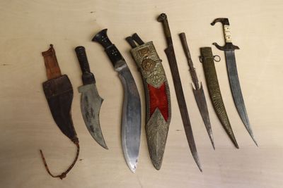 Plusieurs types de couteaux sont exposés sur une table