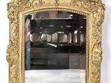 a gold mirror with a bird on the top of it
