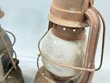 two old lanterns sitting next to each other on a white surface