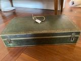 a green suitcase sitting on the floor on the floor