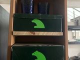 a shelf with three boxes and two cups on top of it