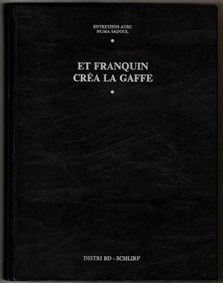 un livre noir posé sur une table blanche