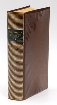 an old book with a brown cover sitting on top of a white surface