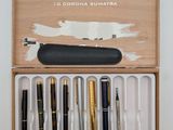 a wooden box with pens and a pen holder in it