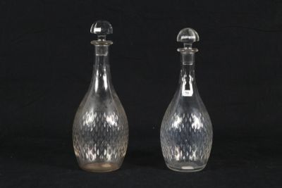 pair of clear glass bottles with silver tops on a black background