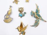 a group of five brooches of various shapes and sizes
