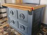 a blue cabinet with drawers and a wooden counter top