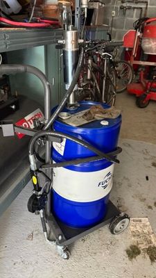 un seau bleu et blanc posé sur un chariot dans un garage