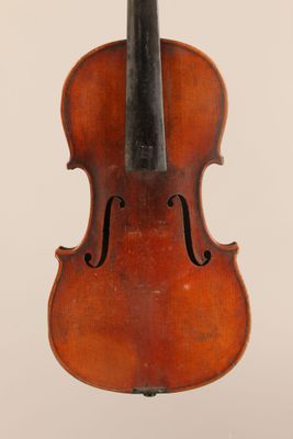 an old violin sitting on top of a white surface
