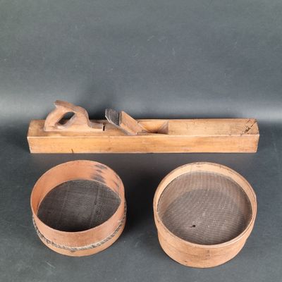 two wooden bowls and a plane on a black surface