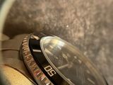 a close up of a watch with a black face