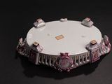 a picture of a white and pink clock on a black surface