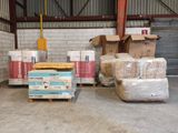 de nombreux cartons et palettes dans un entrepôt où des cartons sont posés à même le sol