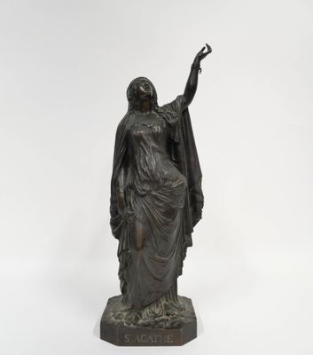 une statue en bronze représentant une femme tenant un oiseau dans la main