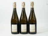 trois bouteilles de vin posées les unes à côté des autres sur une surface blanche
