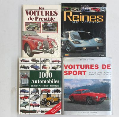 trois livres posés sur une table blanche, avec une voiture de sport rouge en arrière-plan