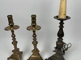 trois bougeoirs en laiton et un porte-bougie sur fond blanc