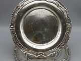 a silver plate on a stand on a gray surface