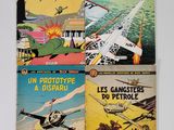quatre bandes dessinées anciennes sont posées sur une surface blanche