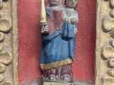 a statue of a woman holding a candle in a gold frame