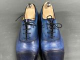 a close up of a pair of blue shoes on a gray surface