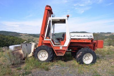 a red tractor that is parked in the grass