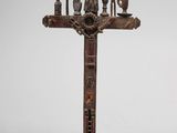 une vieille croix en bois sur laquelle sont accrochés tout un tas d'objets