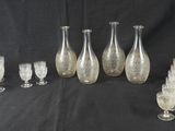 Plusieurs vases et verres en verre sont alignés sur un fond noir